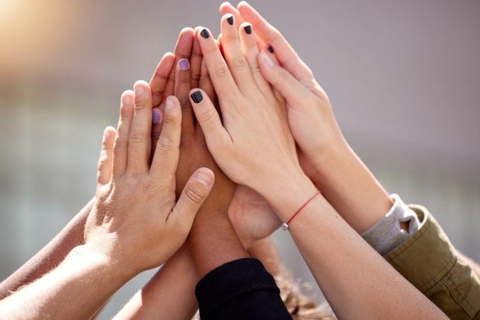 Women putting hands together