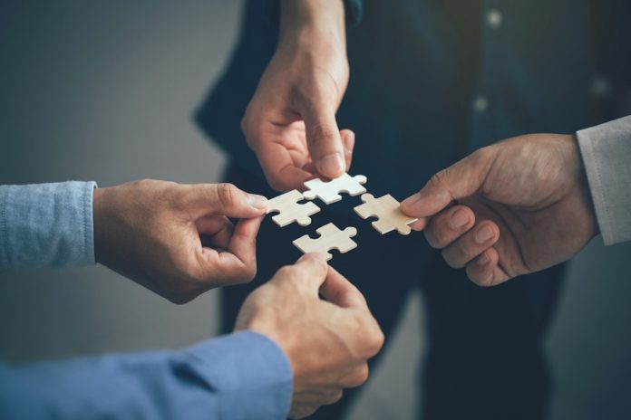 Business people putting jigsaw pieces together