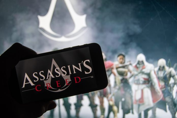 Assassin's Creed The logo of the game series "Assassins Creed" on the display of a smartphone