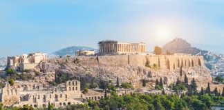 Swintt gets green light to launch in Greece Panoramic view of Athens with Acropolis hill on a hot summer day in Greece.