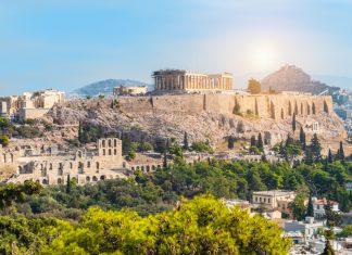 Swintt gets green light to launch in Greece Panoramic view of Athens with Acropolis hill on a hot summer day in Greece.