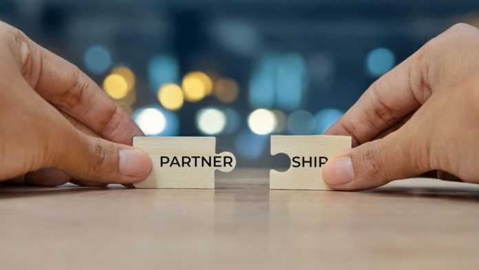 Shutterstock_2570019919 Puzzle pieces with the word partnership on them