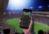 Sports betting a shrewd long-term investment for online casino operators Man looks at sports betting app