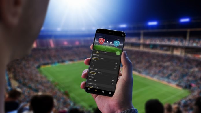 Man looks at sports betting app