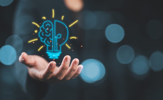 Hand,Holding,Drawing,Virtual,Lightbulb,With,Brain,On,Bokeh,Background innovation concept
