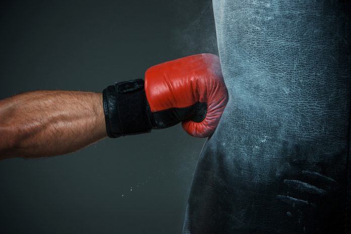 AUSTRAC-financial-crim-fightback A boxing glove punches a punch bag as AUSTRAC fightback against financial crime