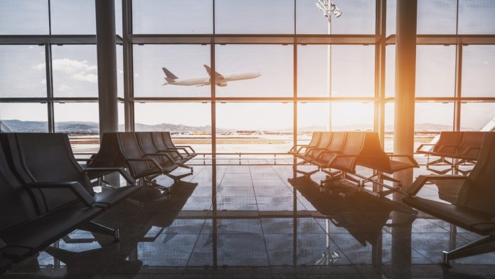 Departure lounge with a plane exiting in the background