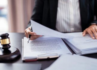 Stake.us embroiled in third sweepstakes lawsuit Lawyer sifts through court documents next to a gavel