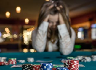GambleAware: Problem gambling self-referrals increased by 50% Person with head in hands at casino table