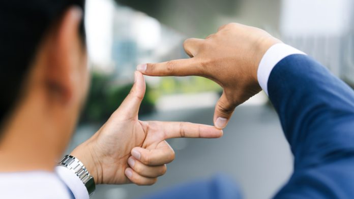 gamzix-hire-regulated-market-focus Businessman creates a rectangle out of his fingers to focus his view