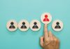 Gentoo Media strengthens leadership team with string of promotions A finger pushes one wooden block forward with a suit stamp on, signifying that block has been chosen to be promoted
