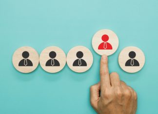 Gentoo Media strengthens leadership team with string of promotions A finger pushes one wooden block forward with a suit stamp on, signifying that block has been chosen to be promoted