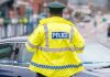 Isle of Man-based companies raided by police to be wound up A police officer stands at the edge of crime scene tape