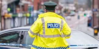 Isle of Man-based companies raided by police to be wound up A police officer stands at the edge of crime scene tape