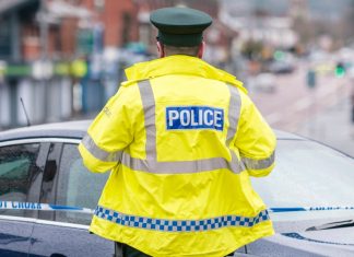 Isle of Man-based companies raided by police to be wound up A police officer stands at the edge of crime scene tape