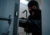 Isle of Man Government warns of criminal infiltration from Southeast Asia A thief in a balaclava sneaks behind a door