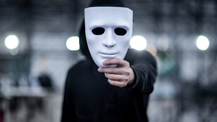 Actor disguising his face with a white mask