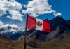 Peru Gambling sector unites against Dina’s Punitive Tax Peru flag with a mountain panorama