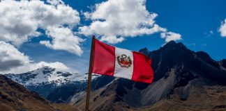 Peru Gambling sector unites against Dina’s Punitive Tax Peru flag with a mountain panorama