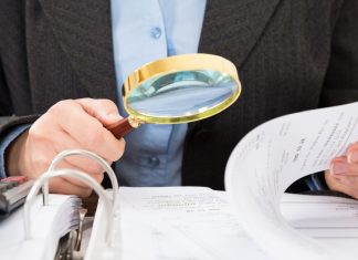 Thailand’s Senate intensifies scrutiny on casino bill Man in suit takes a closer look at papers with a magnifying glass