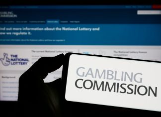 UKGC reveals gambling engagement data amidst financial profiling reform Gambling Commission logo on a phone, the body behind the gambling engagement data