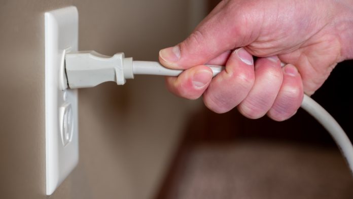 Person begins to pull a cable from the plug