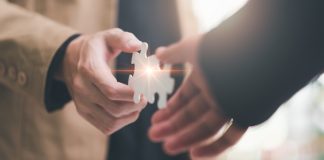 3 Oaks Gaming reinforces Romania presence with WINBET partnership Two hands bring together puzzle pieces, indicating a partnership between the two