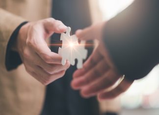 3 Oaks Gaming reinforces Romania presence with WINBET partnership Two hands bring together puzzle pieces, indicating a partnership between the two