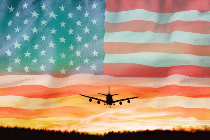 EveryMatrix-expands-SlotMatrix’s-US-horizons-with-Delaware-North US flag with plane in distance as EveryMatrix’s SlotMatrix has expanded its US reach via a partnership with Delaware North’s Betly in West Virginia.