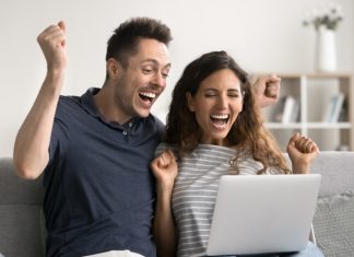 Blixx Gaming launches jackpot experience using FlowsPlay A couple celebrate a jackpot win on a laptop