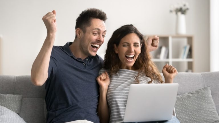 Blixx Gaming launches jackpot experience using FlowsPlay A couple celebrate a jackpot win on a laptop