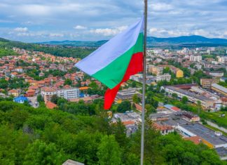 Bulgarian Ministries propose significant online gaming reforms Bulgarian flag sits above a town below