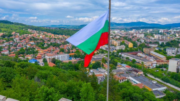 Bulgarian Ministries propose significant online gaming reforms Bulgarian flag sits above a town below