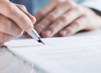 Connecticut edges closer to sweepstakes ban Close up of a mans hands signing a piece of paper