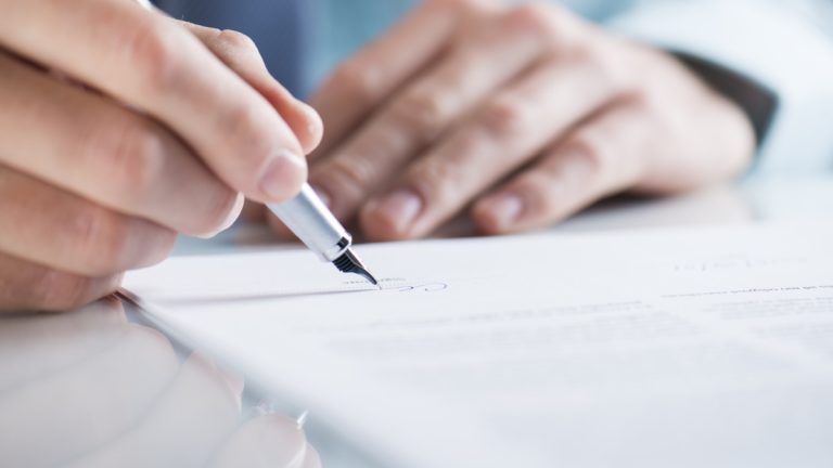 Connecticut edges closer to sweepstakes ban Close up of a mans hands signing a piece of paper