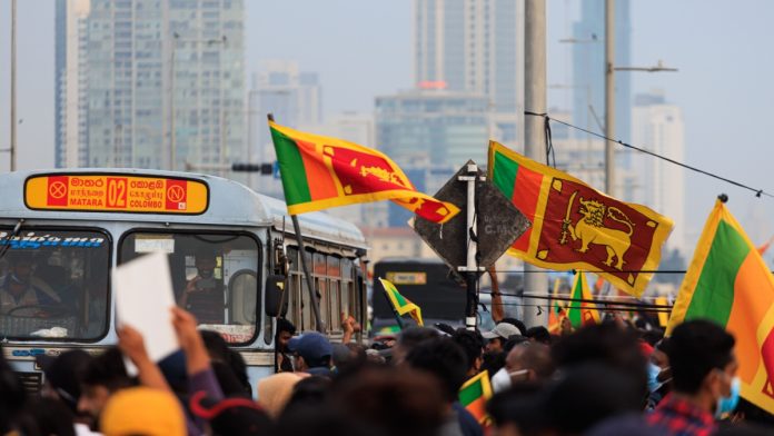 draft-bill-publication-sri-lanka A crowd of people in Sri Lanka holding the country's flag