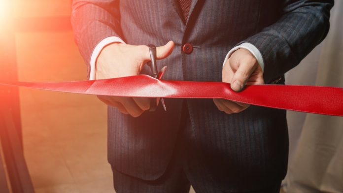 iconic21-live-casino-studio-arb-gaming A man cuts a red ribbon, opening up something new