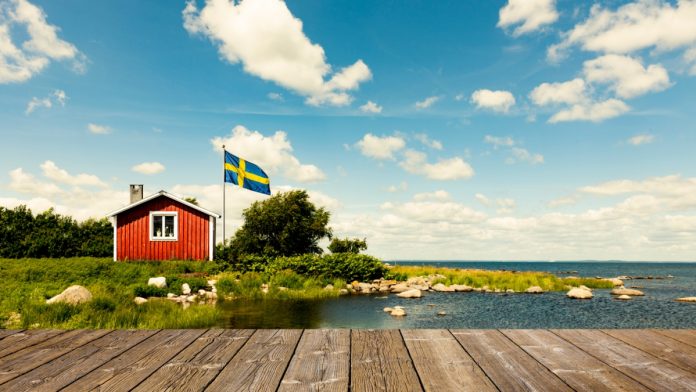 solidicon-sweden-betcomply Swedish flag outside a red house
