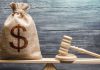 Three operators handed penalty fees over compliance failure in Sweden A gavel sits next to a sack with a dollar sign on, signalling a financial penalty has been handed out