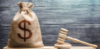 Three operators handed penalty fees over compliance failure in Sweden A gavel sits next to a sack with a dollar sign on, signalling a financial penalty has been handed out