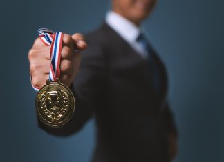 Bally’s International Interactive and Intralot seek global iGaming champion status Businessman holding gold medal