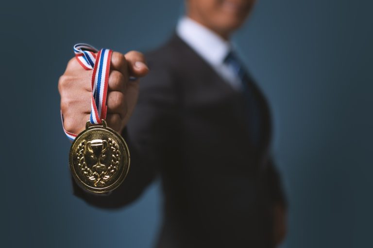 Bally’s International Interactive and Intralot seek global iGaming champion status Businessman holding gold medal