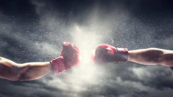 Two boxing gloves come together, indicating a fight