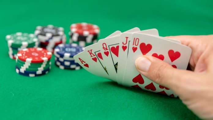 A poker hand showing a royal flush and poker chips