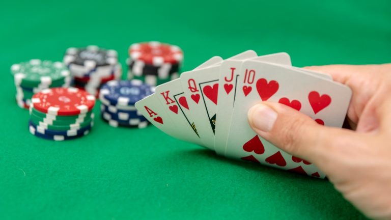 A poker hand showing a royal flush and poker chips