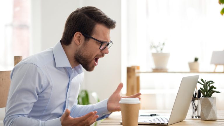 Angry man shouts at a computer