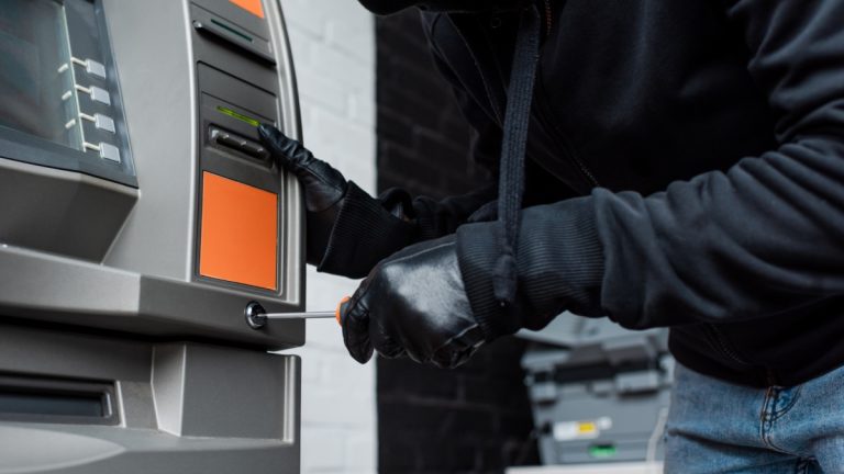 A man is pictured breaking into an ATM