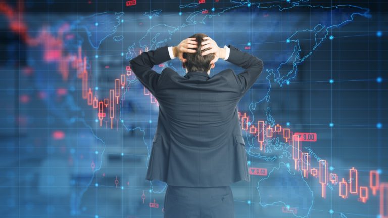 Man has head in hands looking at graph