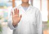 SkyCity requests trading halt as it seeks capital injection Woman in a lab coat holds her hand up, telling someone to halt