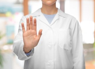 SkyCity requests trading halt as it seeks capital injection Woman in a lab coat holds her hand up, telling someone to halt
